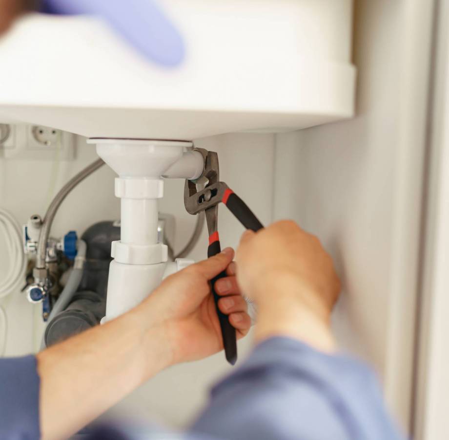 Close up of handyman installs a siphon pipe on the kitchen sink. High quality photo