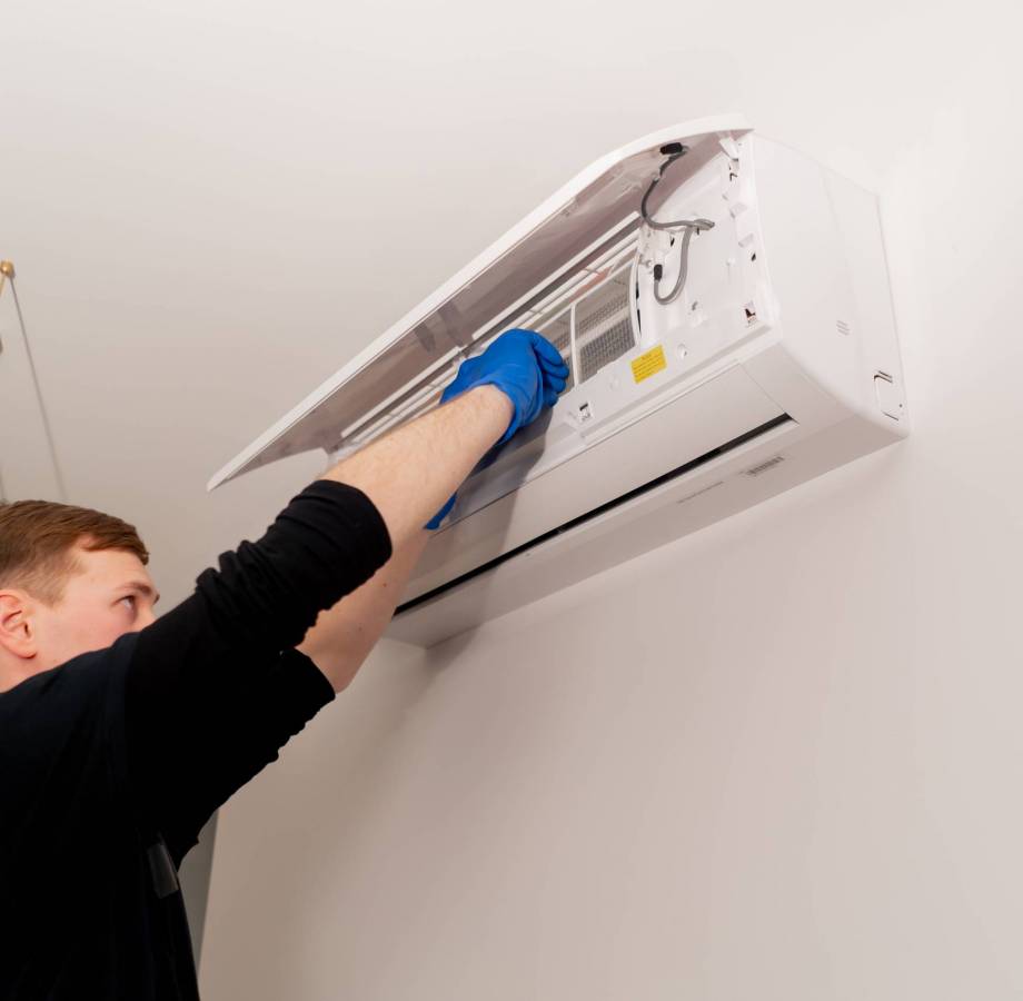 in the apartment the cleaner is cleaning the filters in the air conditioner filling the cooler