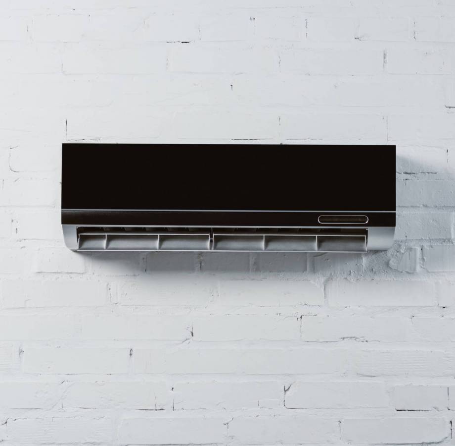 modern air conditioner hanging on white brick wall