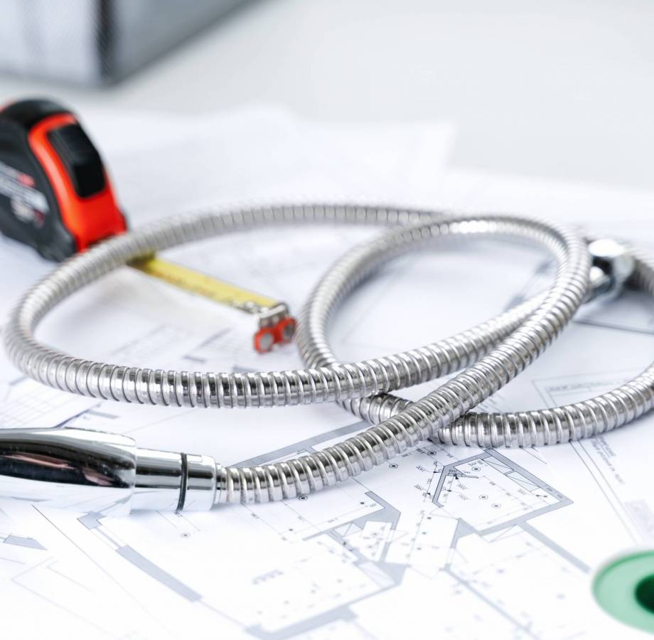 Plumbing project in house.Drawing,diagrams,plan of water supply of apartment,building.Man repairer making repairs at home.Devices,accessories, hose,tap,adjustable wrench,pressure reducer,tape measure.